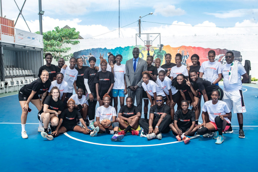 Kaly et un groupe de jeunes femmes à un camp de basketball d’Omega Sports Holding.