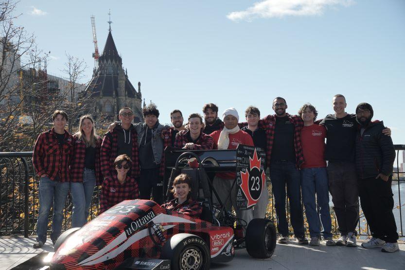 L’équipe Formula uOttawa, avec la capitaine Marie Levin assise dans la voiture de course.
