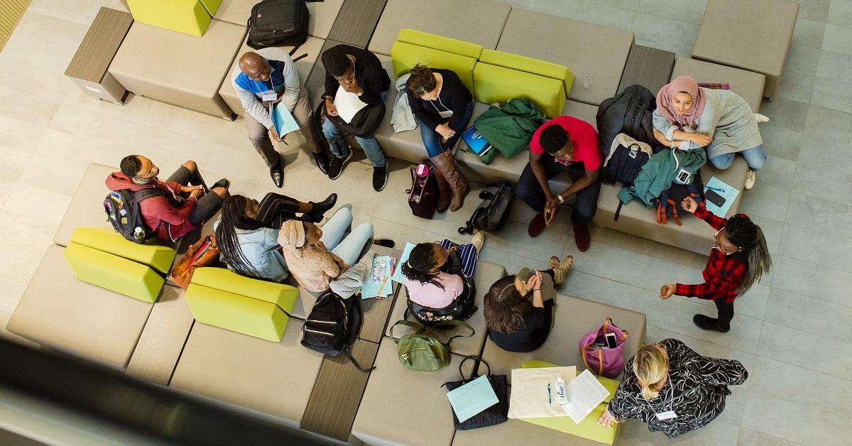 Vue d’oiseau d’une douzaine d’étudiants discutant en groupe.
