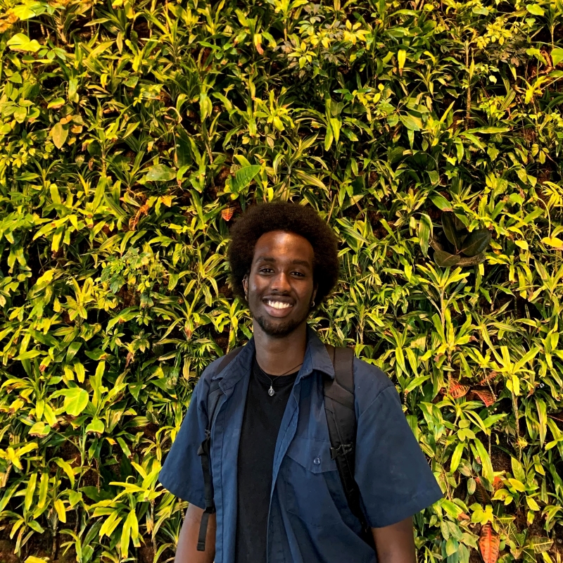Jamal in front of plant wall