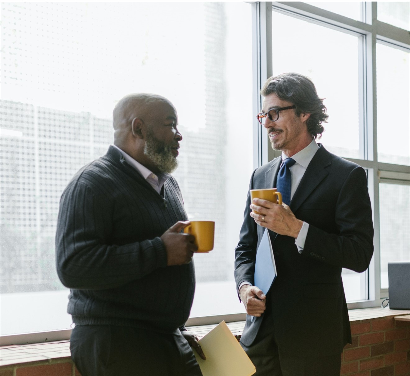 Two men discussing over coffee