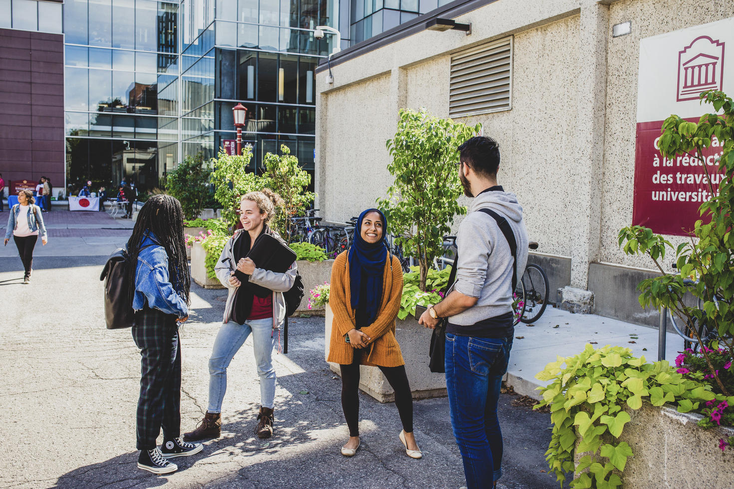 Groupe d'étudiants qui se parlent debout dehors sur le campus