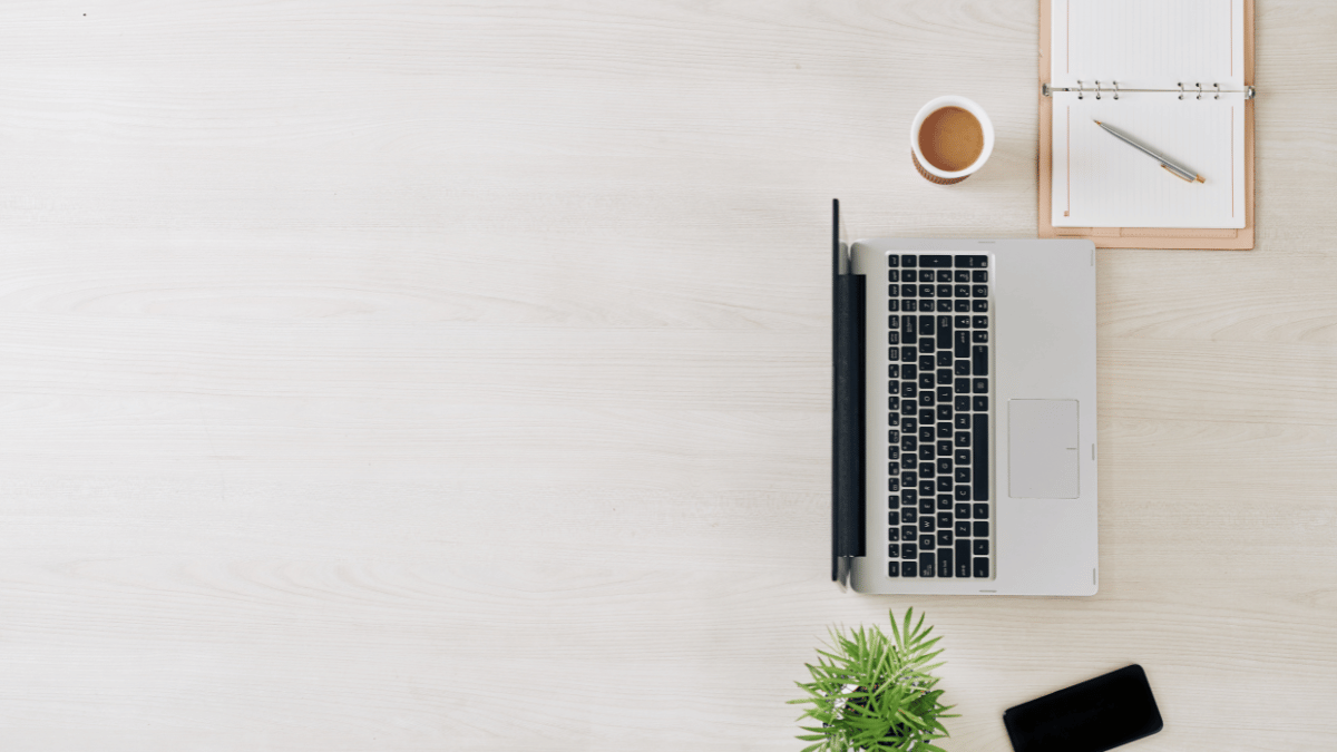 Ordinateur portable sur une table avec une tasse de café et une plante