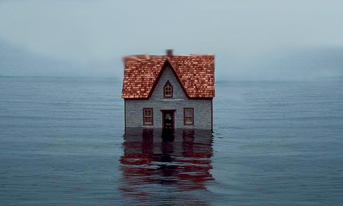 Maison au milieu d'une étendue d'eau.