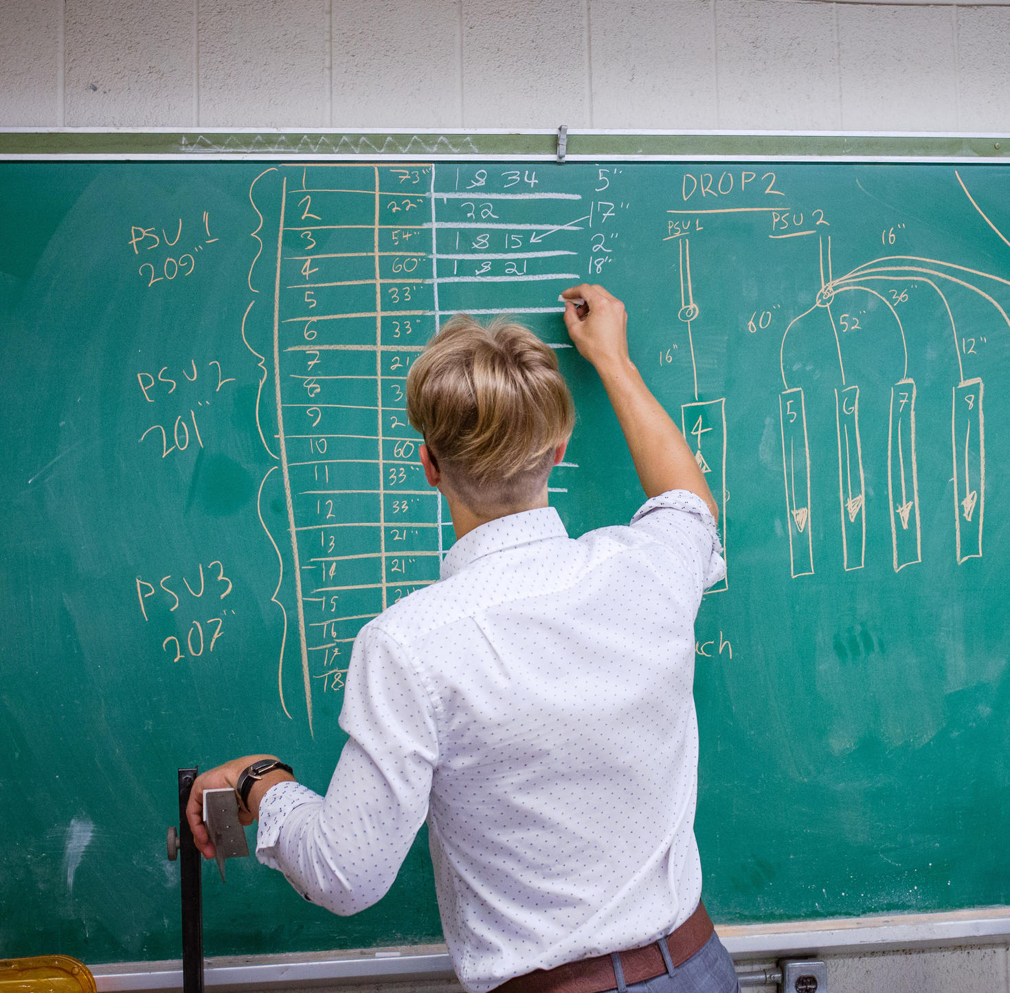 Étudiant écrivant sur un tableau.