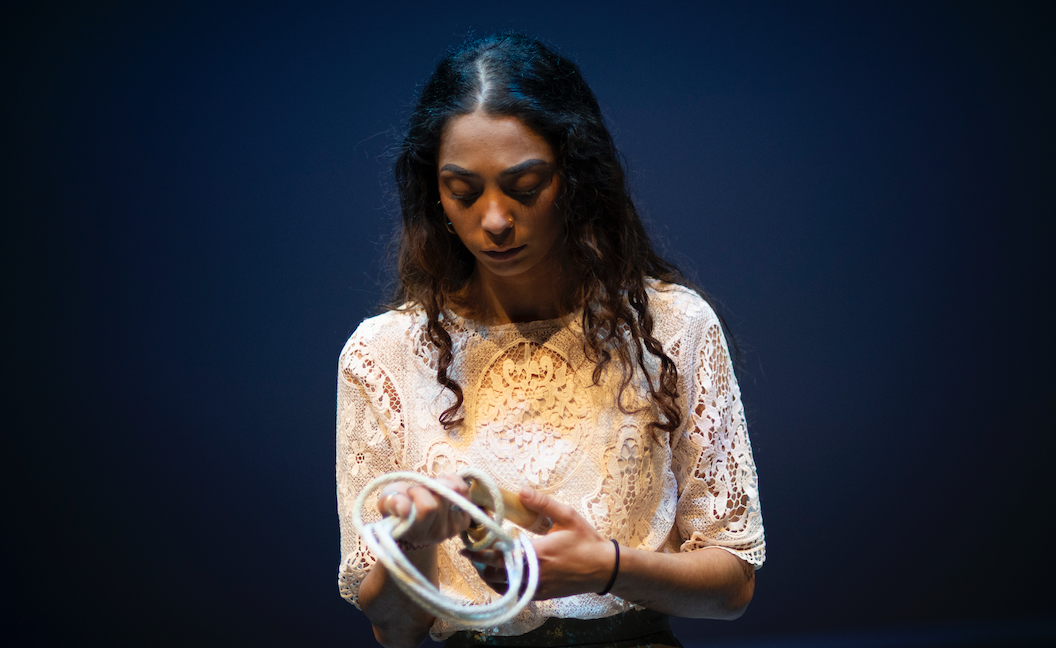 Actrice sur scène tenant une corde.