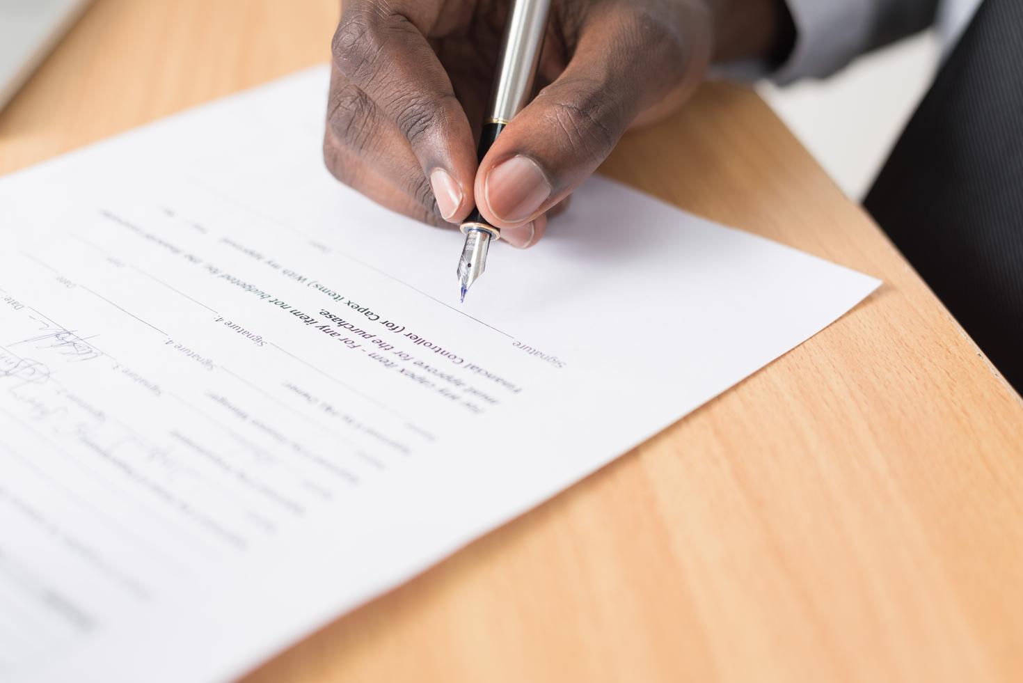 plan rapproché d'une personne qui signe un document