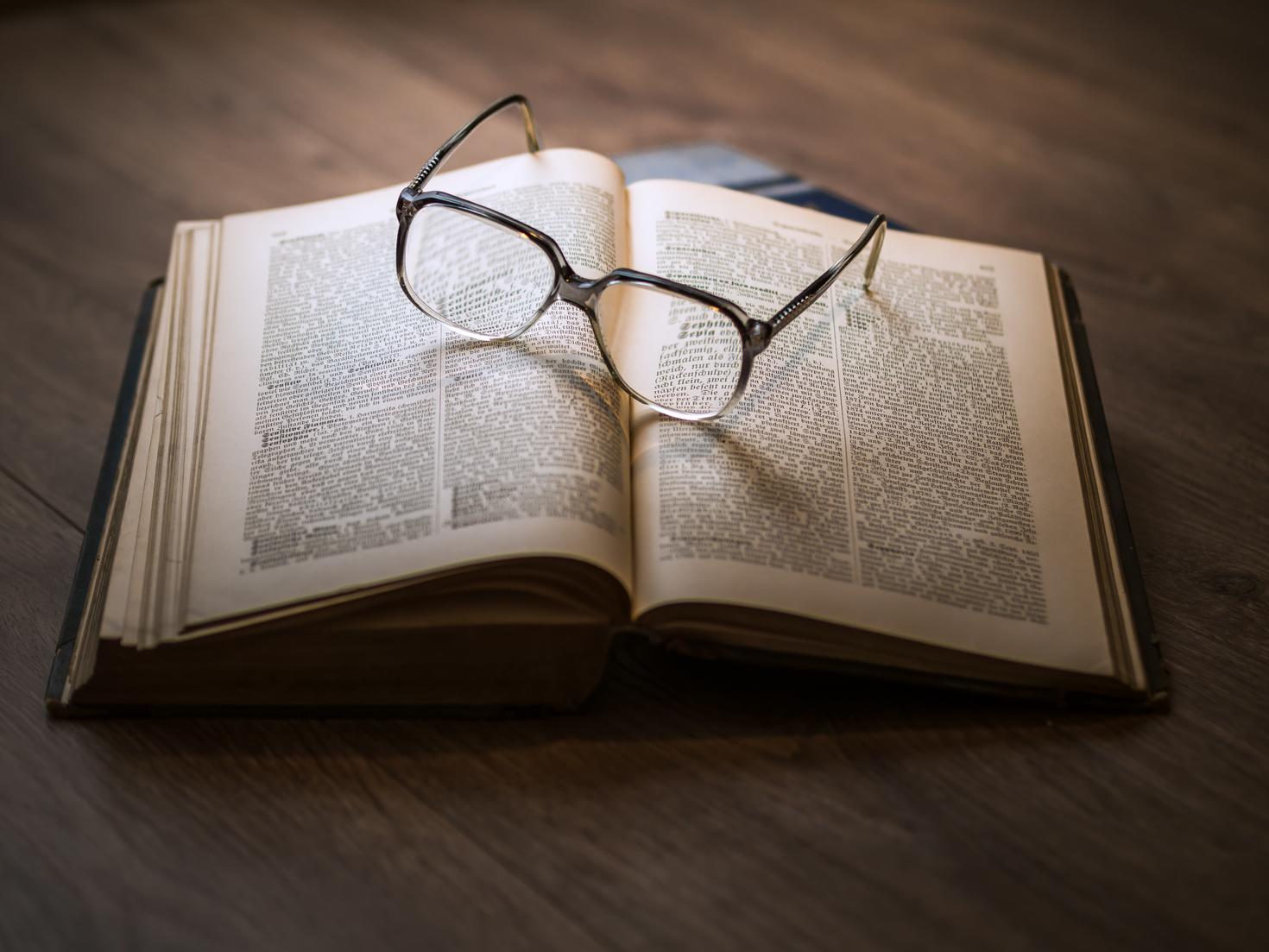 Livre ouvert avec une paire de lunettes sur les pages.