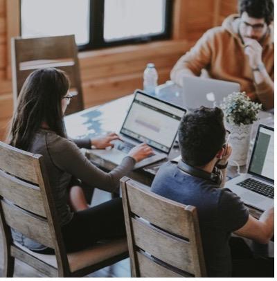 trois personnes travaillant à l'ordinateur
