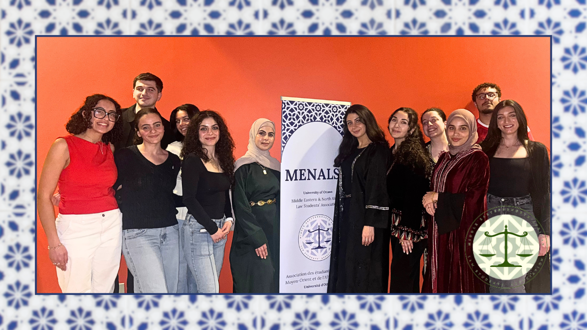 Un groupe de douze étudiant(e)s d'âge universitaire se tient debout, tout sourire. Deux d'entre eux portent un hijab et une robe longue. Ils se tiennent à côté d'un panneau sur lequel est inscrit « MENALSA ».