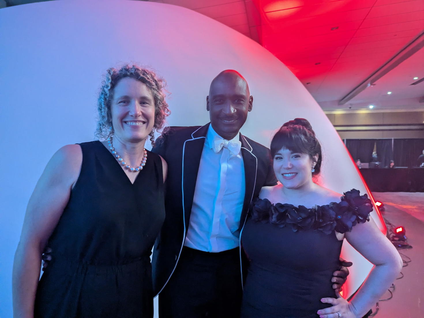 Un homme et deux femmes participantes au gala ont posé