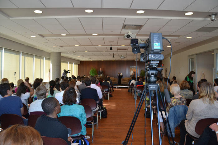 Appareil d'enregistrement assis au fond d'une salle de conférence pleine de monde.