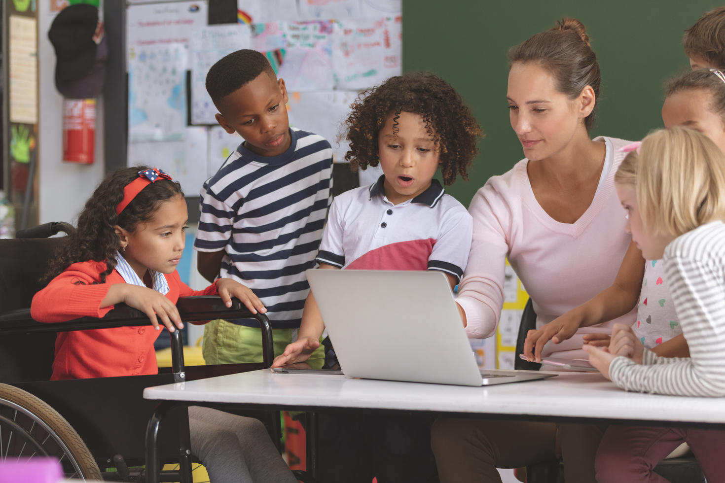 Teacher in classroom teaching young kids.