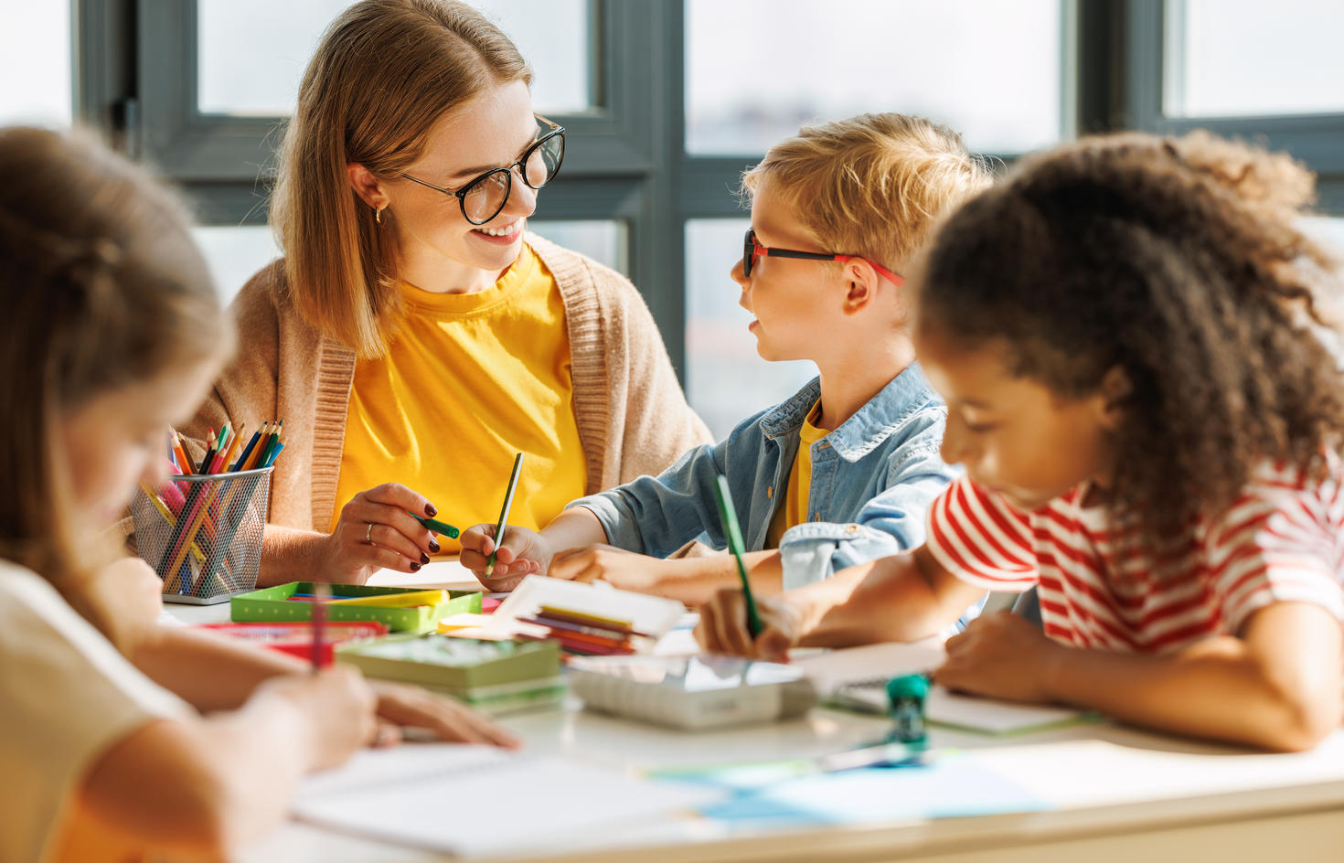 enseignant avec un groupe d'enfant multi-éthnique qui dessinent