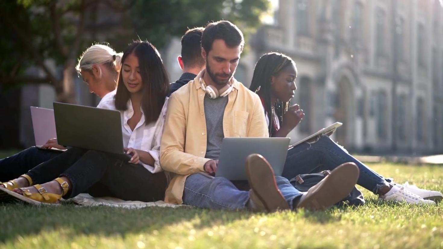 students sitting on the grass 