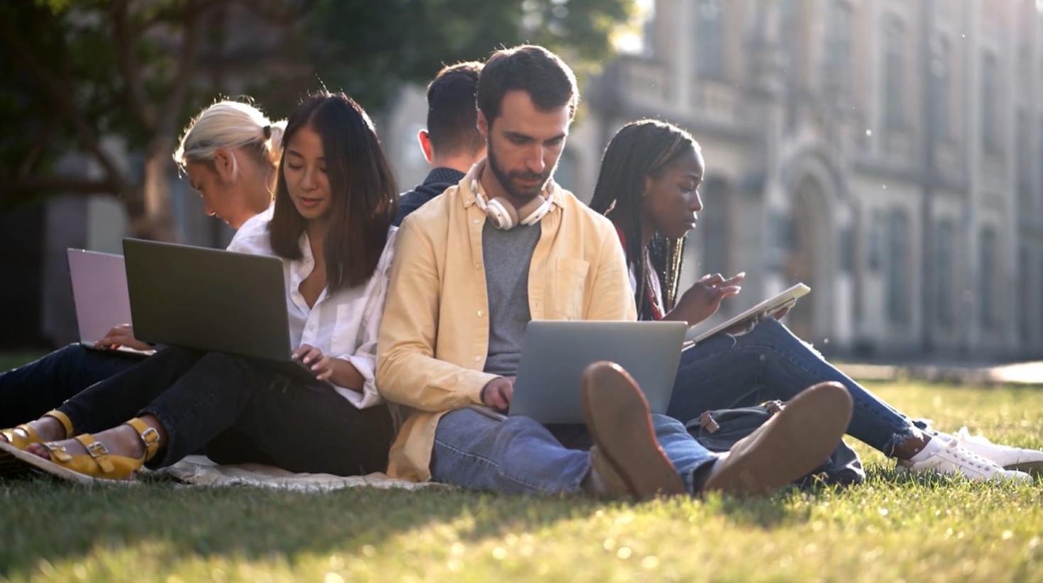 students sitting on the grass 