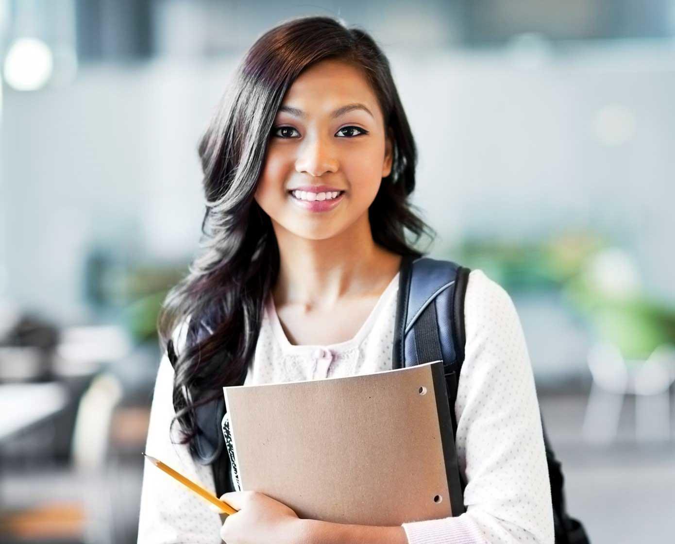 student from ethnic background holding book