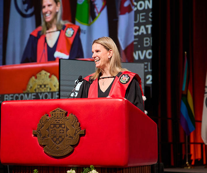 Kim St-Pierre, debout derrière un podium