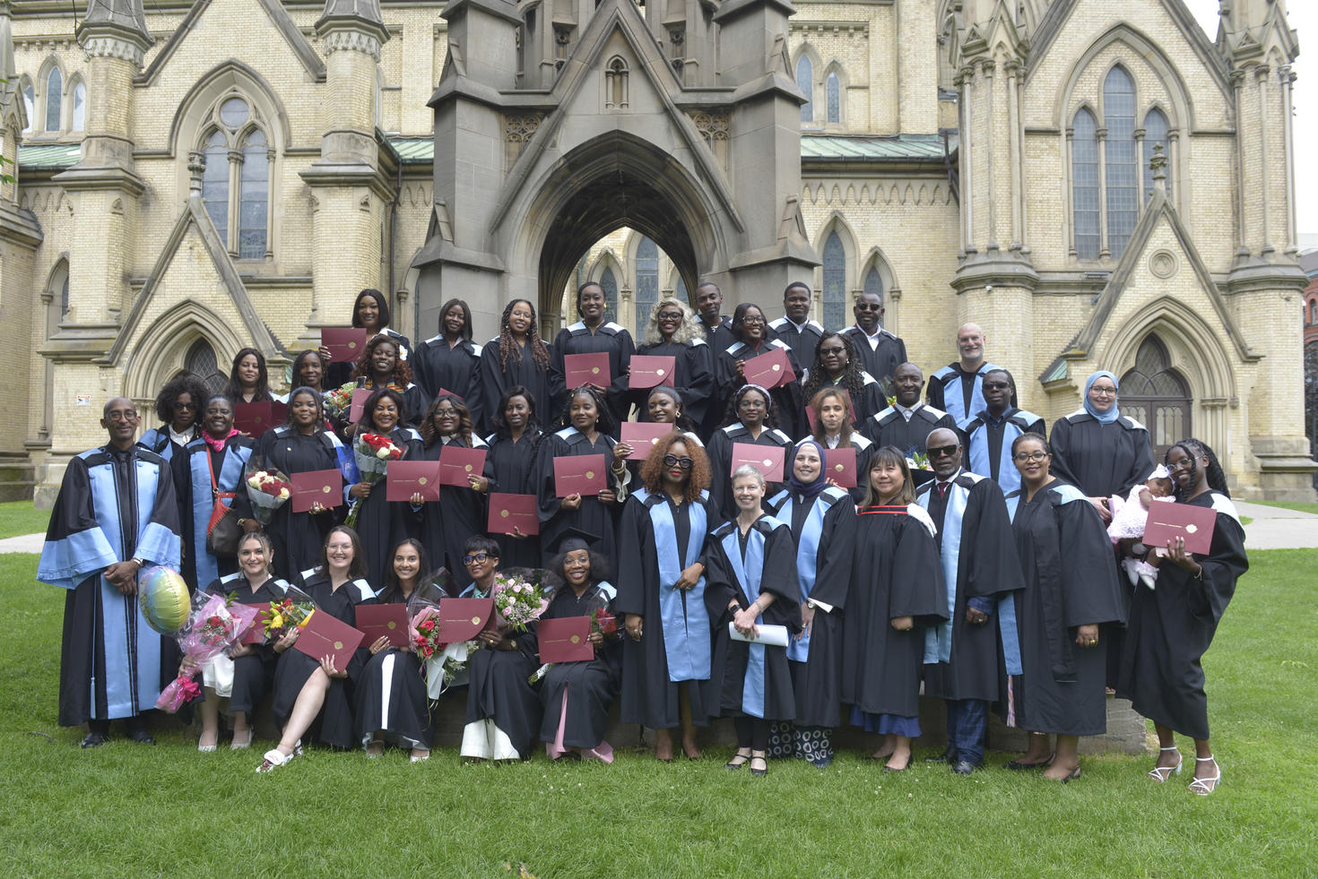 Group of graduates standing in front of a castle.