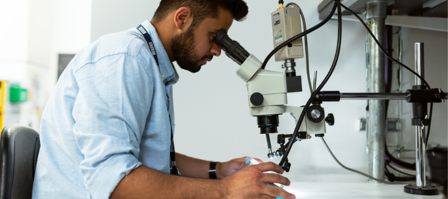 Student looking through microscope.