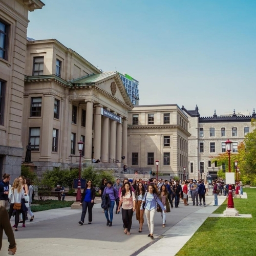 Groupe d'étudiants marchant près du pavillon Tabaret sur le campus de l'Université d'Ottawa.
