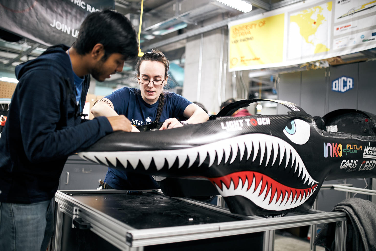 Des étudiants dans l'espace de collaboration John McEntyre qui travaillent sur une auto.