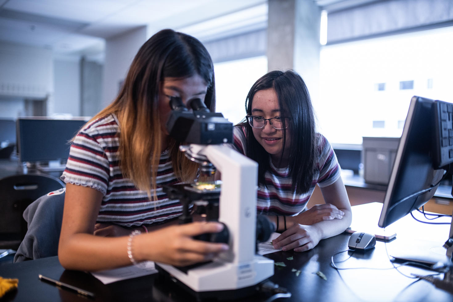 Adolescent dans un laboratoire regardant dans un microscope.