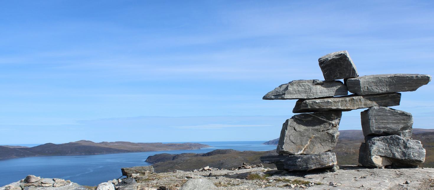 Vue d'une vallée, d’une rivière et d’un Inuksuk du sommet d’une montage