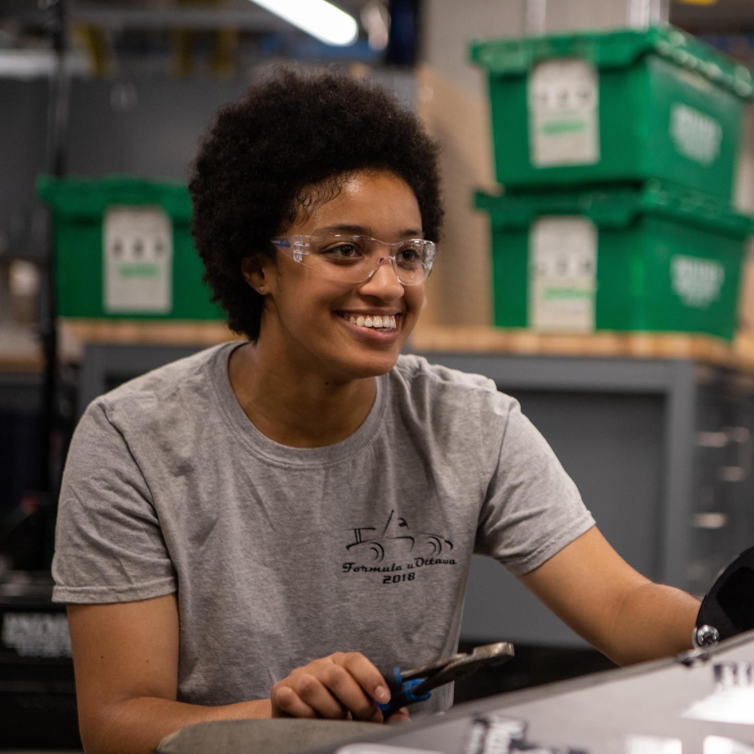 Étudiant souriant avec des lunettes de sécurité.