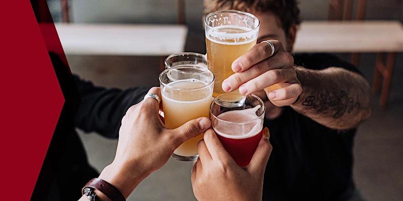 Un groupe de personnes lève des verres de bière pour porter un toast