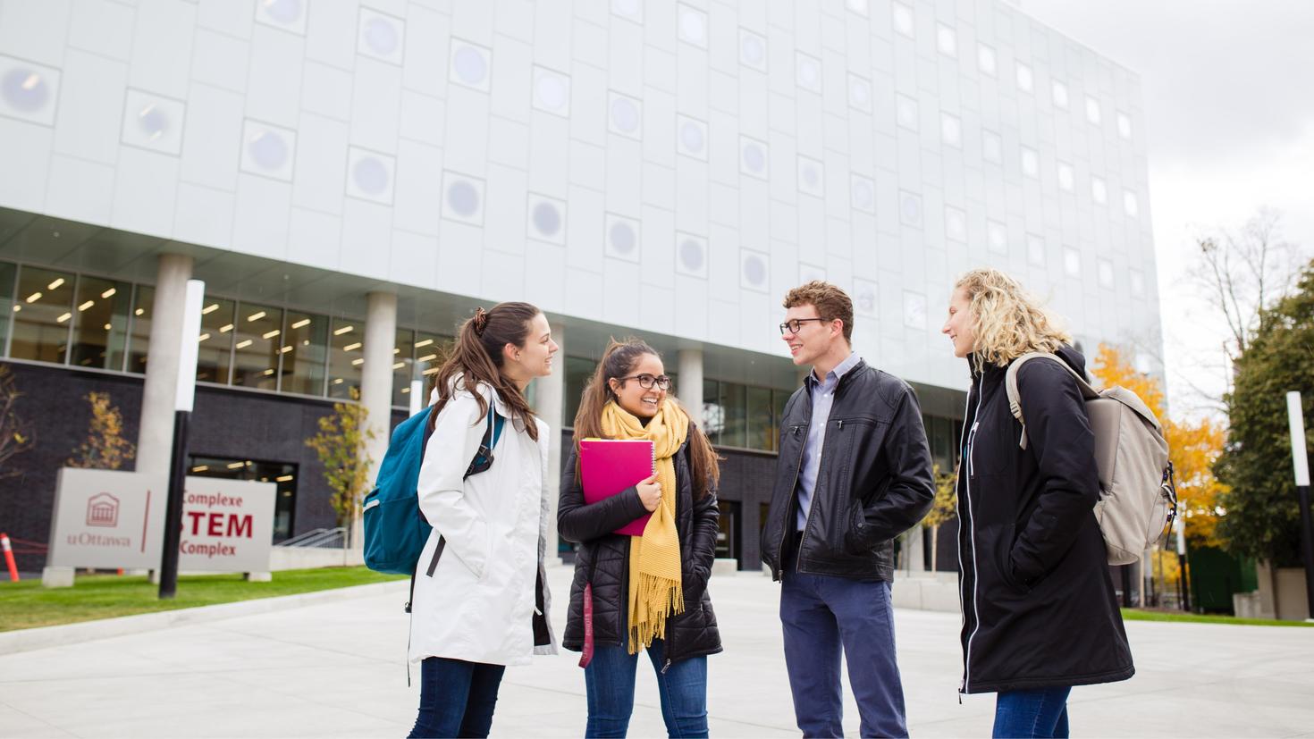 Des étudiants discutent devant le complexe STEM.