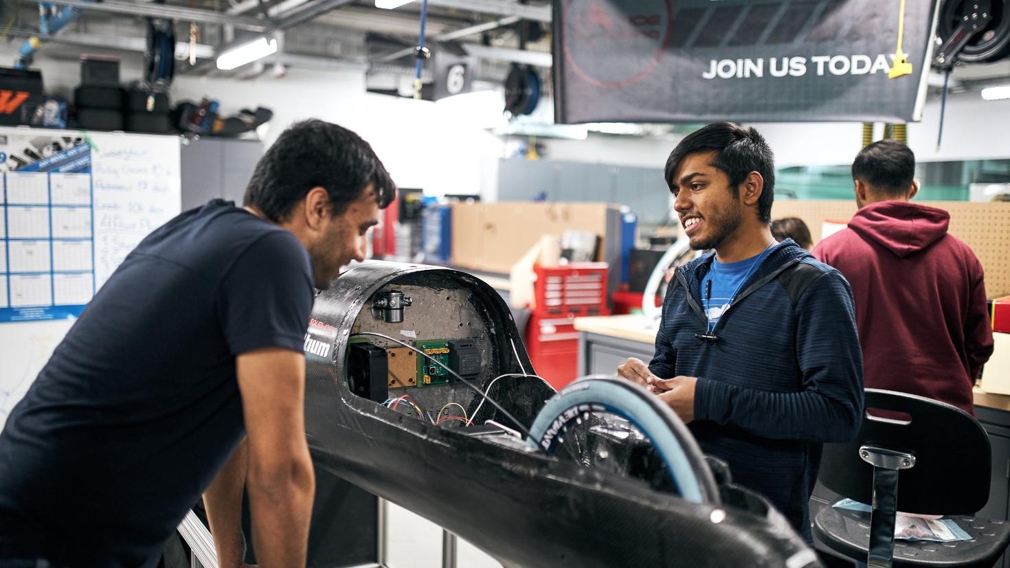 Des étudiants travaillent sur une voiture dans l'Espace de collaboration John McEntyre.