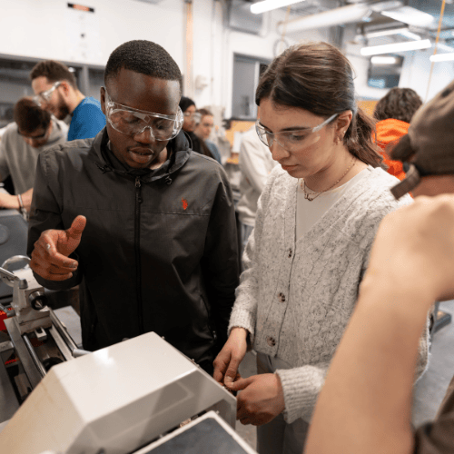 Un étudiant en train d’expliquer comment utiliser une machine.