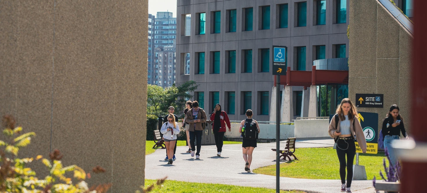 Des étudiantes et étudiants marchent devant le bâtiment ÉITI à l'Université d'Ottawa.
