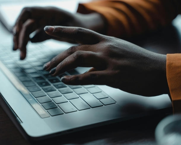 Une personne tappe sur un clavier d'ordinateur.