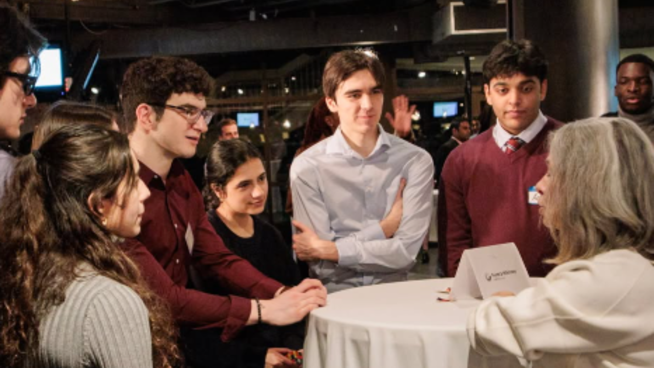 Des personnes vêtues de manière professionnelle se sont rassemblées autour d'une table.