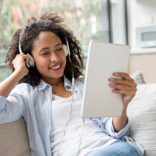 Femme avec des écouteurs et une tablette