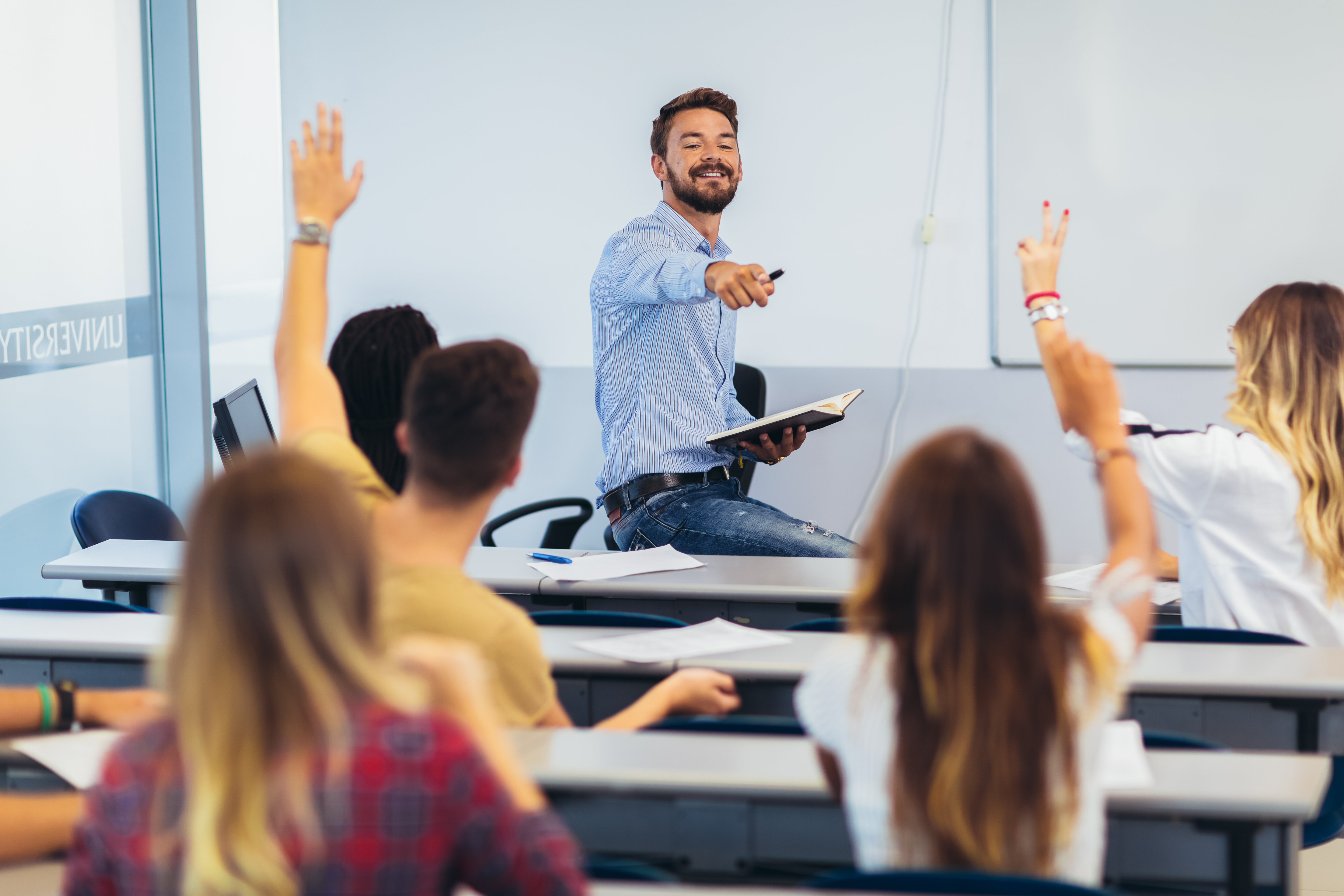 Lycéens levant la main sur une classeHigh school students raising hands on a class