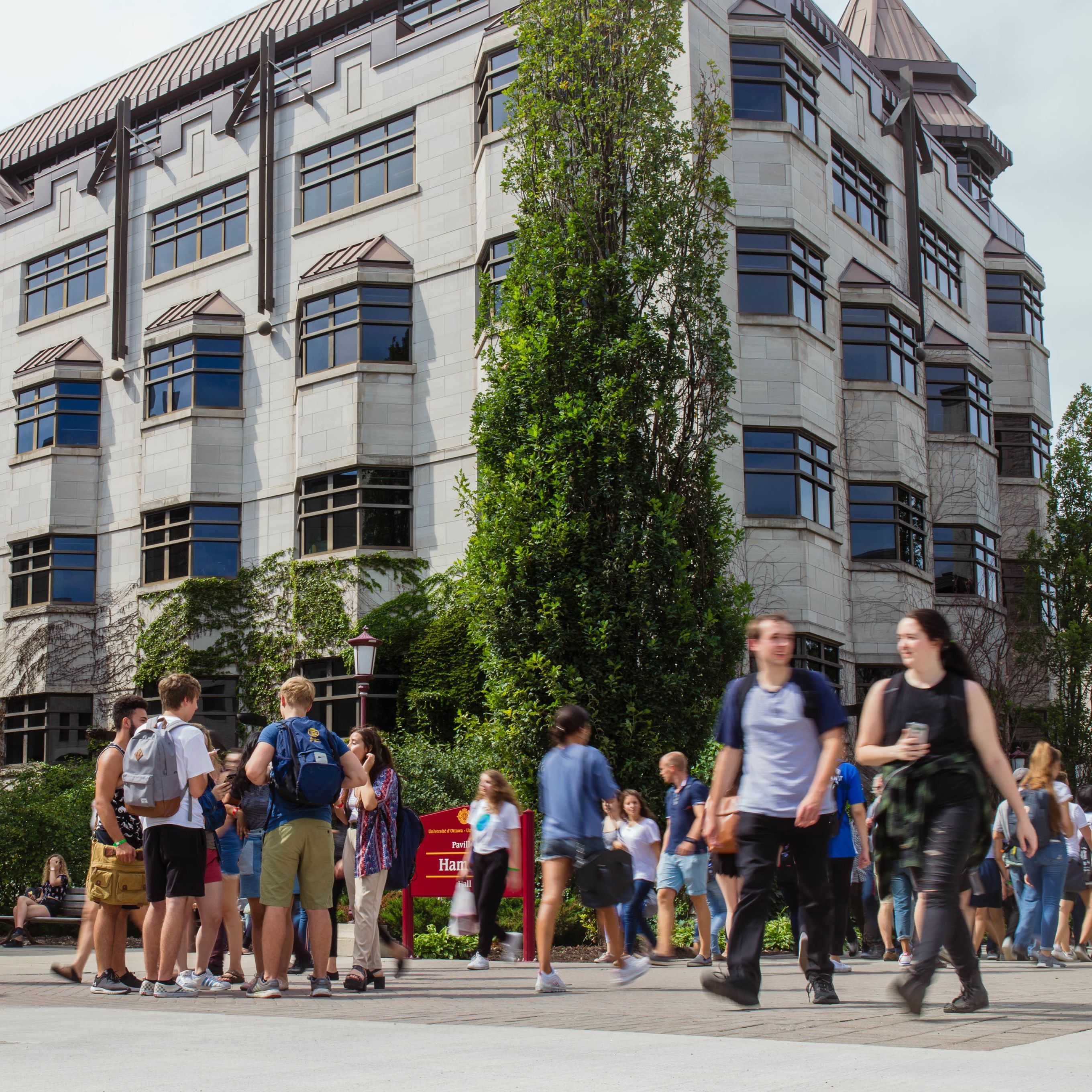 Des étudiants marchent devant le bâtiment du campus
