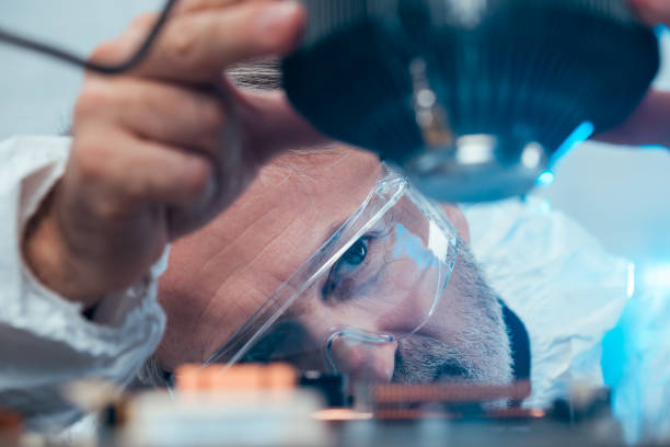 Scientifique portant des lunettes de protection inspectant de près un équipement dans un laboratoire