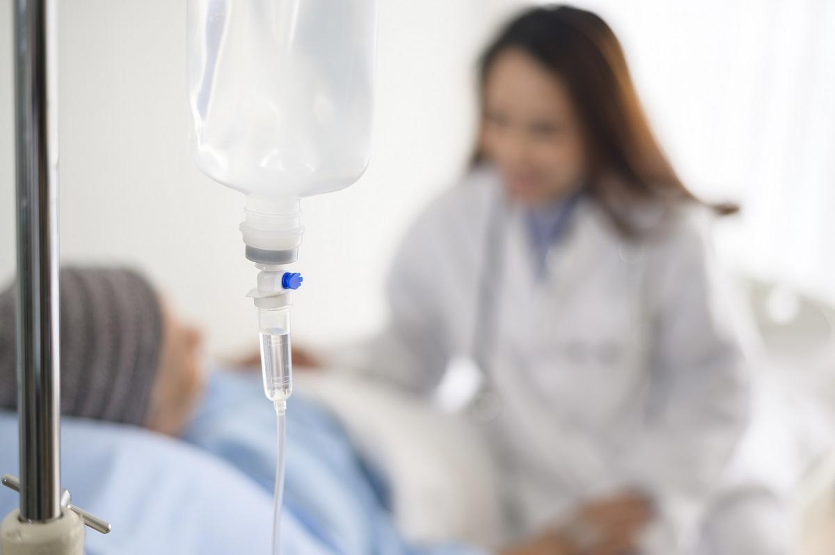 Personne atteinte du cancer portant un foulard sur la tête à la suite d’un traitement de chimiothérapie, qui consulte une médecin dans un hôpital, symbolisant la recherche de la Faculté de médecine de l’Université d’Ottawa visant à vaincre les cancers résistants aux médicaments.
