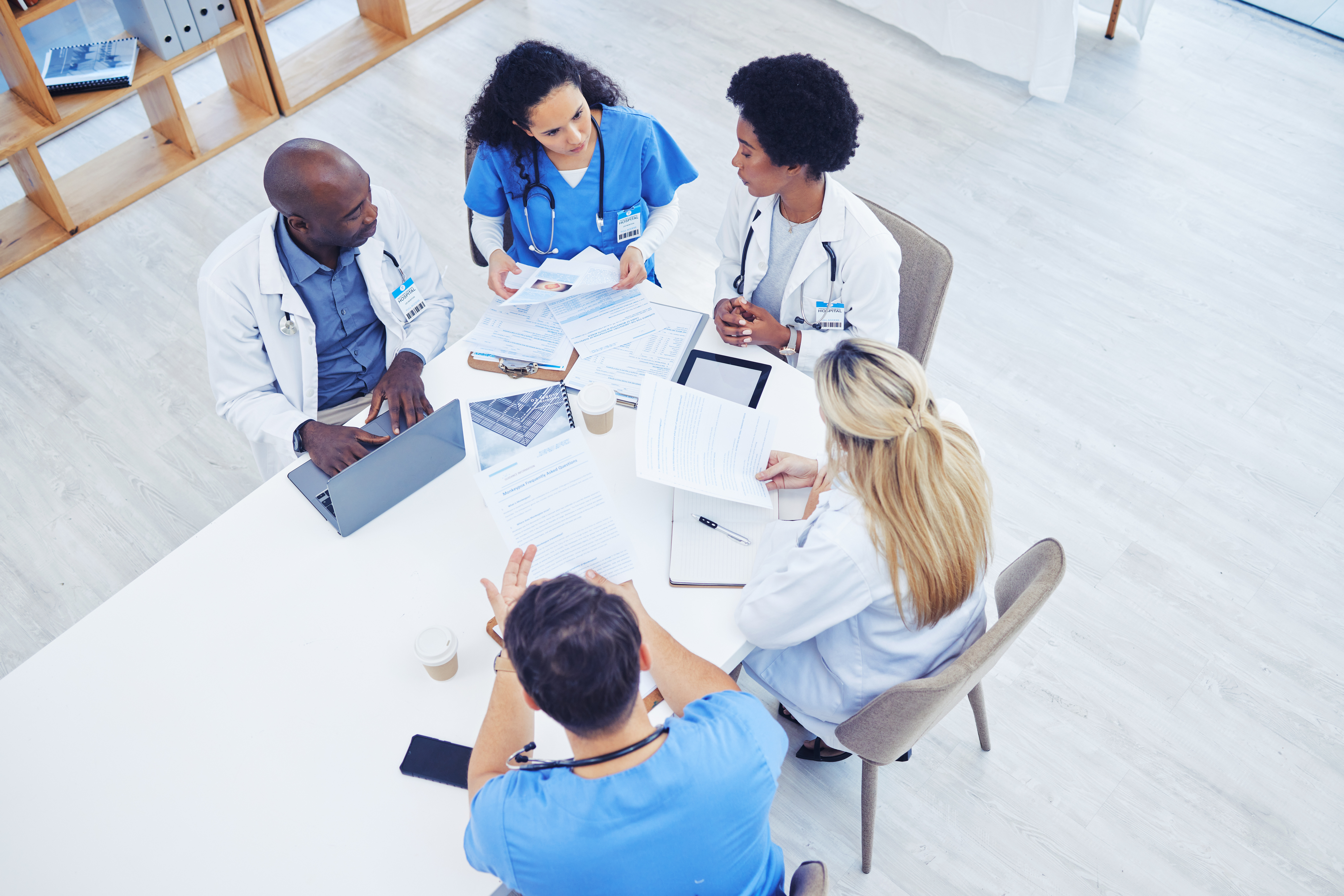 Ci-dessus, soins de santé et réunion de médecins sur ordinateur portable pour la recherche, la planification et l'innovation à l'hôpital. Brainstorming entre médecins, équipe et experts de la santé.