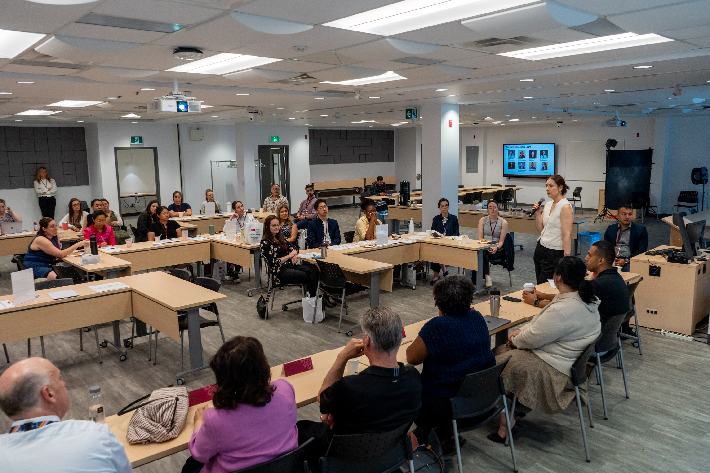 Room full of attendees watching a presentation conducted by Faculty Development Director Dr. Laura Visentin