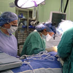Three physicians operating on patient