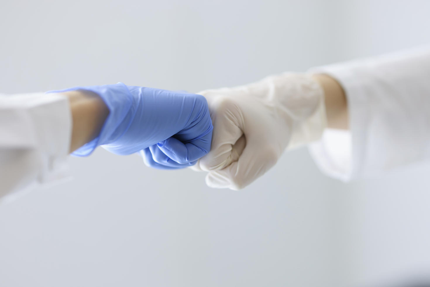 Deux cliniciens se frappant le poing en travaillant en collaboration.