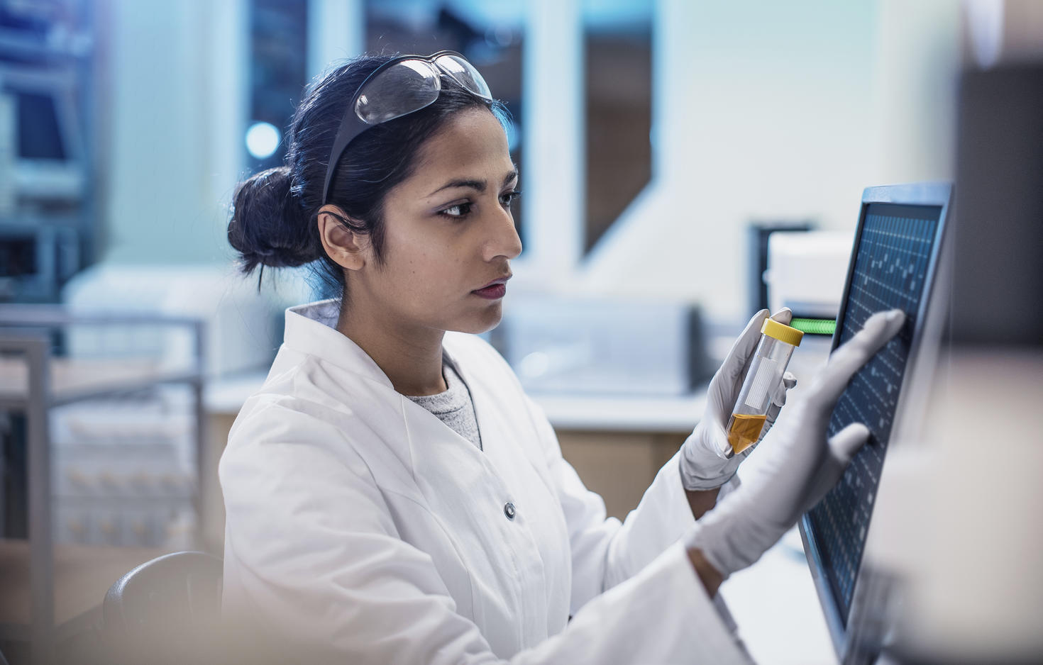 Femme scientifique travaillant dans un laboratoire et utilisant un ordinateur.