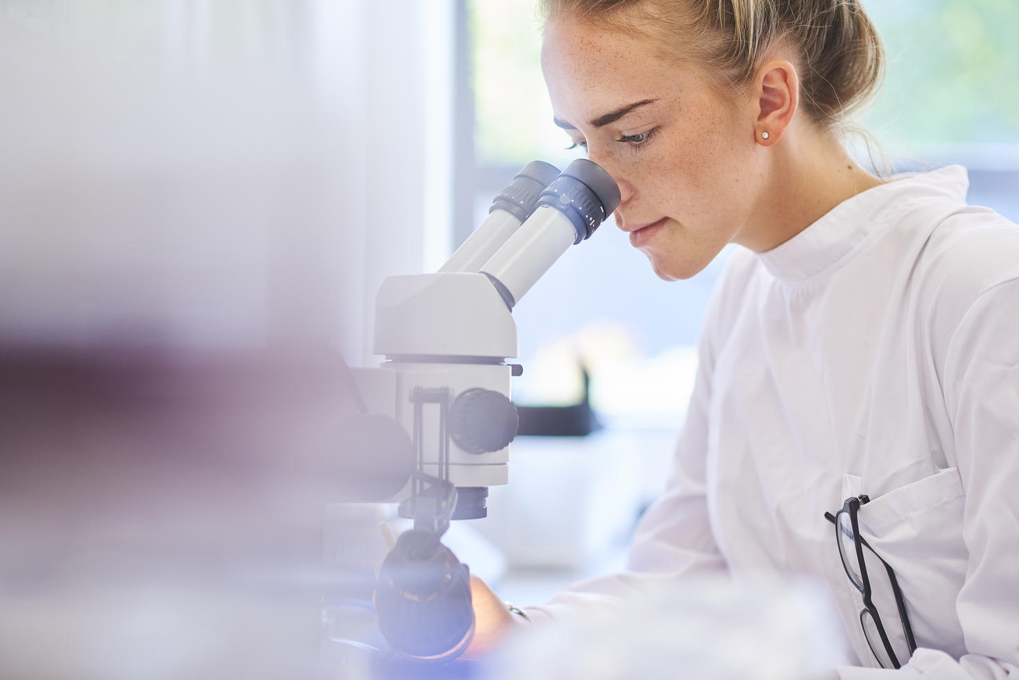 Femme scientifique regardant dans un microscope