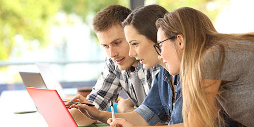 Trois étudiants étudiant ensemble en ligne