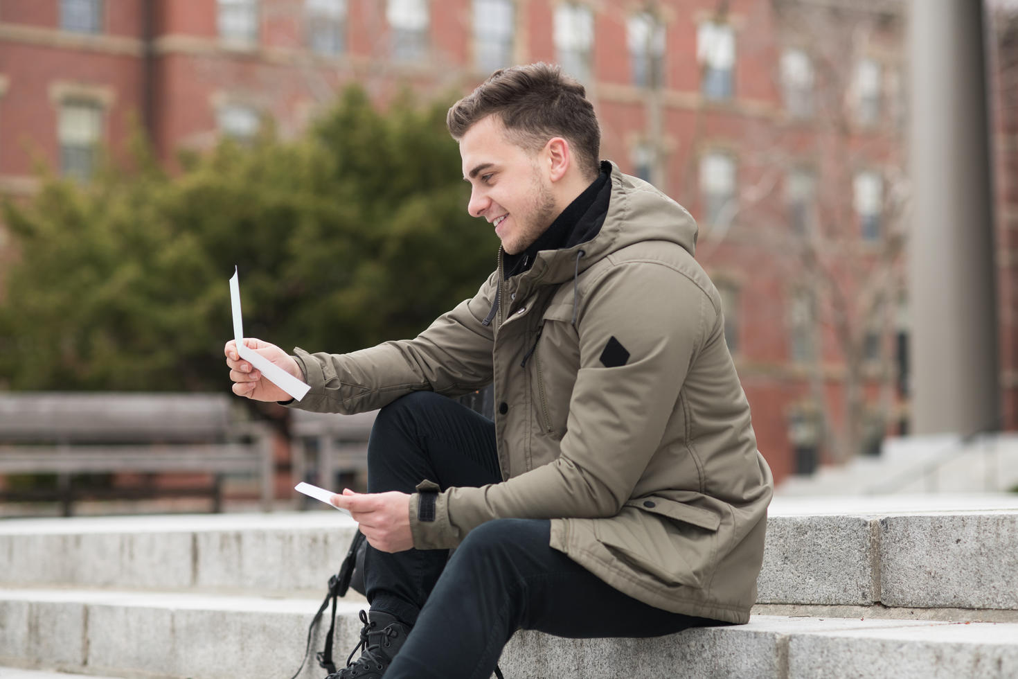 Un étudiant heureux lit une lettre d'approbation après des examens universitaires ou une offre d'emploi.