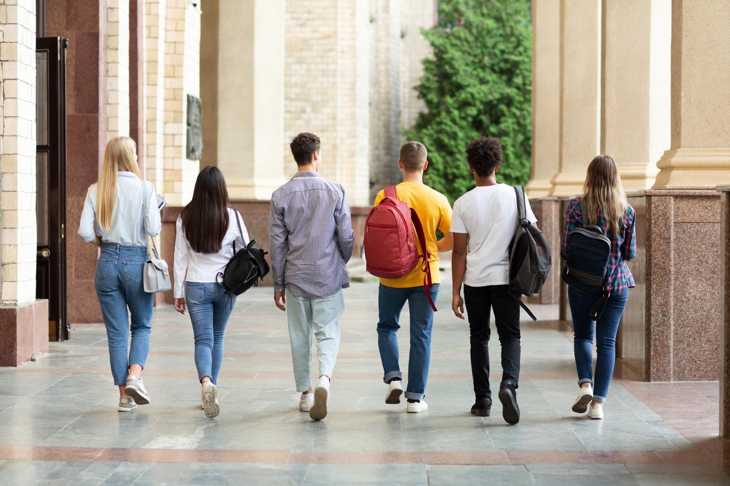 Six étudiants marchant dans un campus universitaire